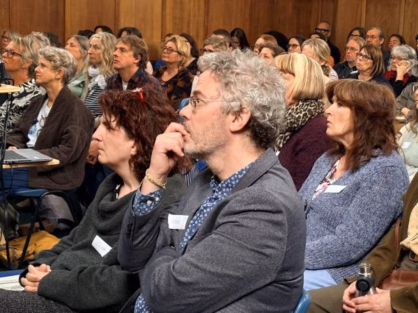 Robert Marx and Clara Strauss listening to the keynote speaker at the conference